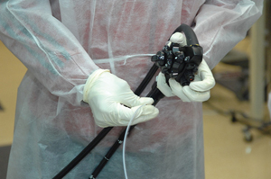 Image of doctor in full PPE holding a Scope imager