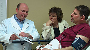 Image of a doctor showing a patient and wife notes