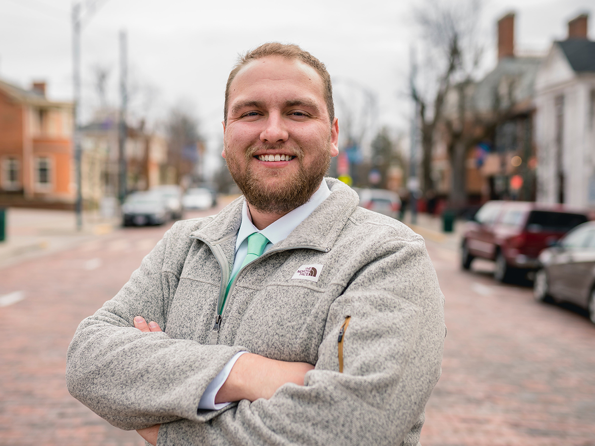 man smiling outdoors wearing dress shirt and tie