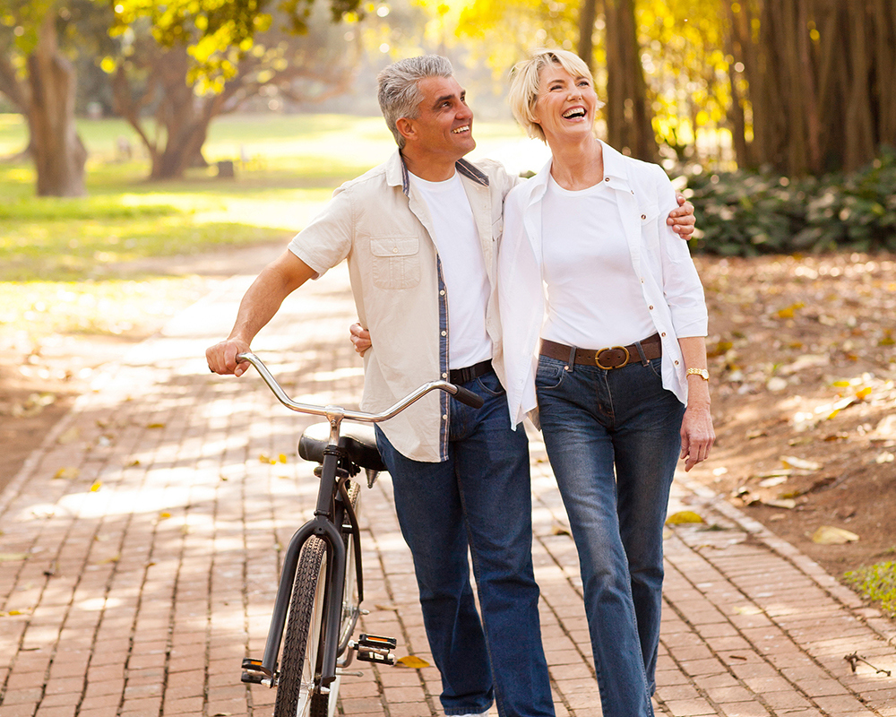 happy middle-aged couple walking through the park
