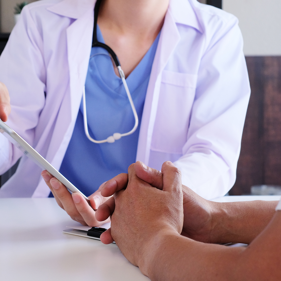 doctor sitting with a man looking at a plan chart