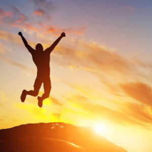 man outside jumping in the sunset