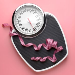 Scale with a pink tape measure on it.